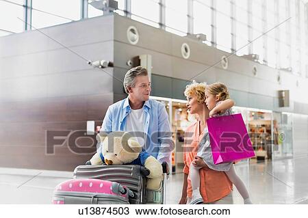 Family on holiday trip walking in airport with lens flare View Large Photo Image Stock Image - Family on holiday trip walking in airport with lens flare. Fotosearch