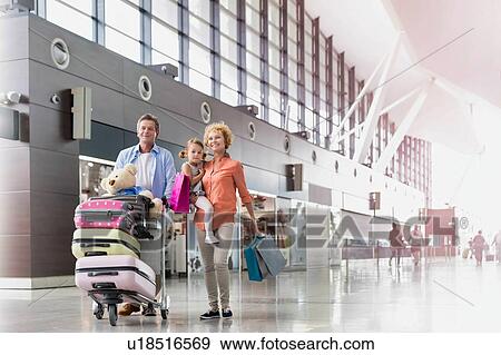 Stock Photo - Family on holiday trip walking in airport with lens flare. Fotosearch