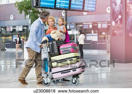 Family on holiday trip walking in airport with lens flare View Large Photo Image Stock Photo - Family on holiday trip walking in airport with lens flare. Fotosearch