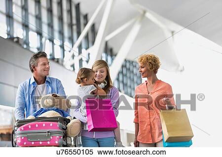 Stock Photography - Family on holiday trip walking in airport. Fotosearch