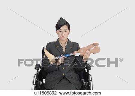 Female US military officer in wheelchair holding artificial limb over gray backgrounds View Large Photo Image Stock Image - Female US military officer in wheelchair holding artificial limb over gray backgrounds. Fotosearch