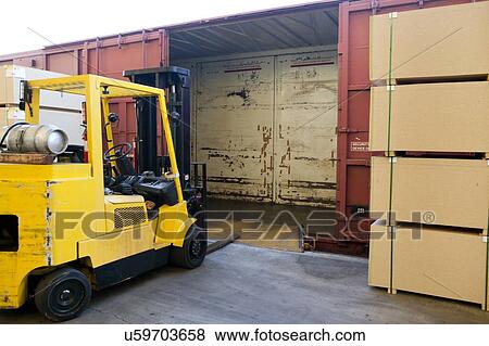 Stock Photo - Fork Lift Truck loading industrial railway carriage. Fotosearch