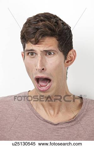 Frightened young man screaming against white background View Large Photo Image Stock Photography - Frightened young man screaming against white background. Fotosearch