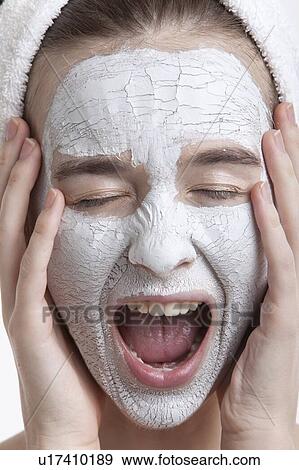 Stock Photo - Frustrated young woman with face pack screaming against white background. Fotosearch