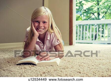 Girl lying on carpet, reading book View Large Photo Image Stock Photo - Girl lying on carpet, reading book. Fotosearch