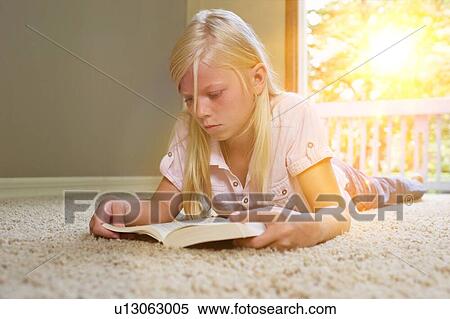 Girl lying on carpet, reading book View Large Photo Image Stock Photography - Girl lying on carpet, reading book. Fotosearch