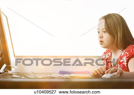 Girl with Down syndrome using computer at school View Large Photo Image Stock Photo - Girl with Down syndrome using computer at school. Fotosearch