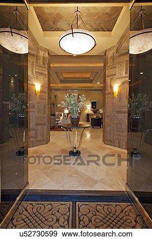 Stock Photo - Glass doors open to luxurious foyer. Fotosearch