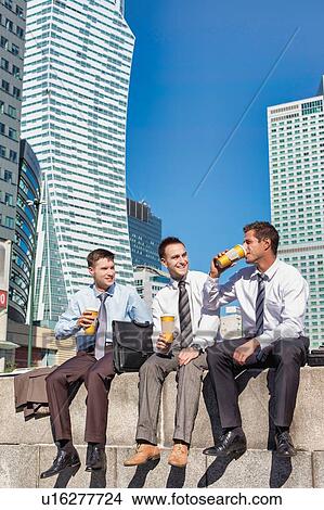 Group of colleagues sitting and talking while drinking coffee after work View Large Photo Image Picture - Group of colleagues sitting and talking while drinking coffee after work. Fotosearch