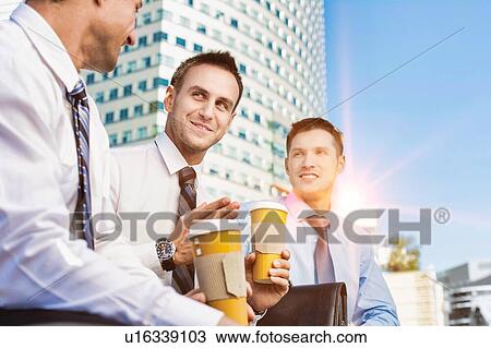 Group of colleagues sitting and talking while drinking coffee after work View Large Photo Image Stock Image - Group of colleagues sitting and talking while drinking coffee after work. Fotosearch