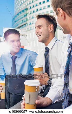 Group of colleagues sitting and talking while drinking coffee after work View Large Photo Image Stock Photo - Group of colleagues sitting and talking while drinking coffee after work. Fotosearch