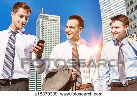 Stock Photo - Group of colleagues walking while talking after work. Fotosearch