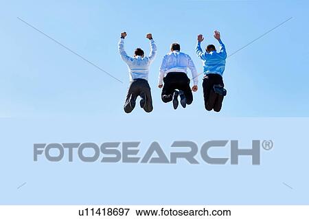 Stock Photo - Group of mature businessmen jumping on office rooftop. Fotosearch