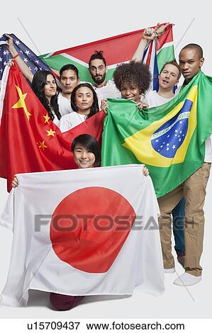 Stock Photo - Group of multi-ethnic friends holding various national flags against white background. Fotosearch