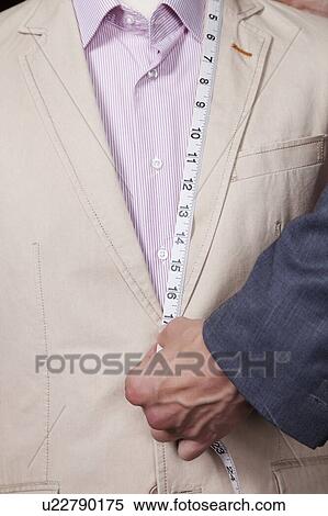 Stock Photography - Hand measuring suit length with tape. Fotosearch