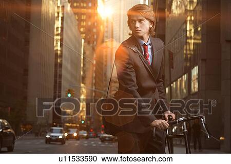 Handsome brunette business man commuting to work by bicycle wearing suit and tie View Large Photo Image Stock Image - Handsome brunette business man commuting to work by bicycle wearing suit and tie. Fotosearch