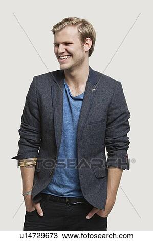 Happy businessman in smart casuals looking away against gray background View Large Photo Image Stock Image - Happy businessman in smart casuals looking away against gray background. Fotosearch