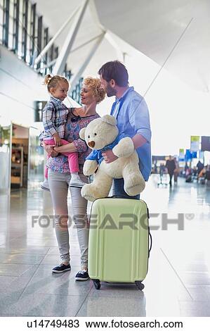 Happy family on a holiday arriving at the airport with lens flare View Large Photo Image Stock Image - Happy family on a holiday arriving at the airport with lens flare. Fotosearch