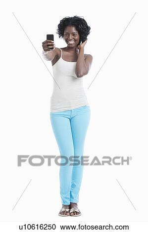 Happy young African American woman taking self portrait over white background View Large Photo Image Stock Image - Happy young African American woman taking self portrait over white background. Fotosearch