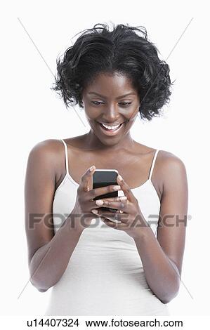 Happy young African American woman text messaging over white background View Large Photo Image Picture - Happy young African American woman text messaging over white background. Fotosearch