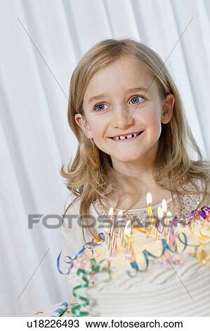 Happy young girl looking away with candles burning on birthday cake View Large Photo Image Stock Image - Happy young girl looking away with candles burning on birthday cake. Fotosearch