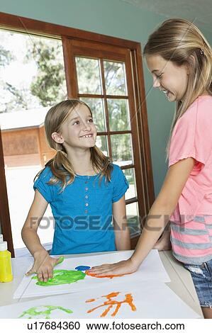 Happy young sisters making hand prints on paper View Large Photo Image Stock Image - Happy young sisters making hand prints on paper. Fotosearch