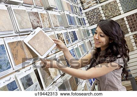 Happy young store clerk arranging samples in display View Large Photo Image Stock Image - Happy young store clerk arranging samples in display. Fotosearch
