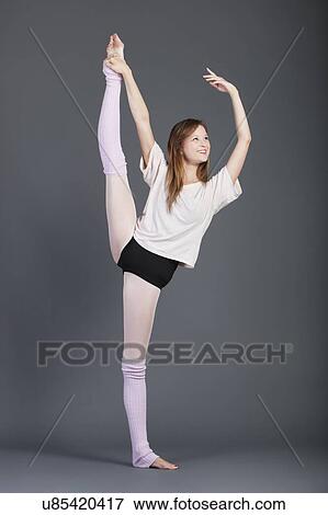 Happy young woman performing ballet over grey background View Large Photo Image Stock Photo - Happy young woman performing ballet over grey background. Fotosearch