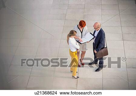 Picture - High angle view of business people discussing plans over document . Fotosearch
