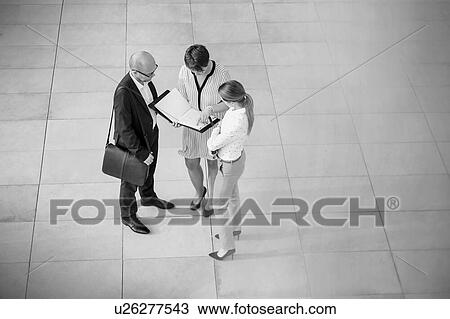 High angle view of business people discussing plans over document View Large Photo Image Stock Image - High angle view of business people discussing plans over document . Fotosearch