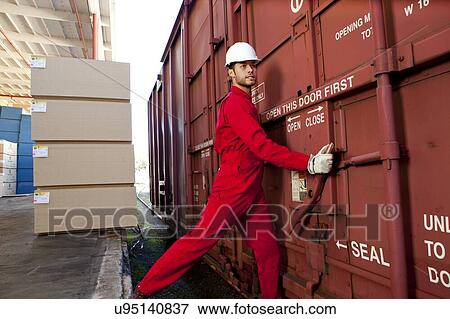Hispanic worker opening industrial railway carriage View Large Photo Image Stock Photo - Hispanic worker opening industrial railway carriage. Fotosearch