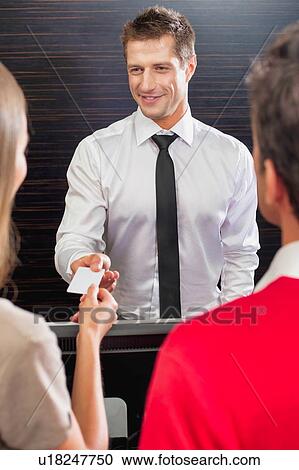 Hotel receptionist giving key card to the guest in lobby View Large Photo Image Stock Image - Hotel receptionist giving key card to the guest in lobby. Fotosearch