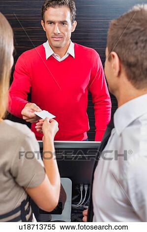 Hotel receptionist giving key card to the guest in lobby View Large Photo Image Stock Photography - Hotel receptionist giving key card to the guest in lobby. Fotosearch