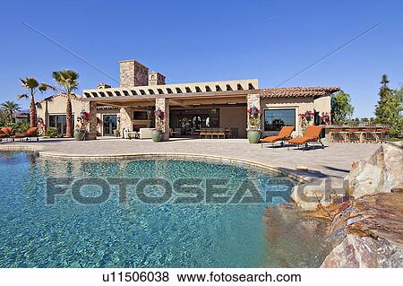 Stock Photo - House exterior with pool and waterfall. Fotosearch