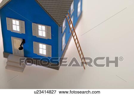 Stock Photo - Illuminated little blue model house with ladder. Fotosearch