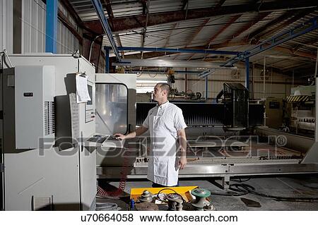Industrial factory worker operating machinery View Large Photo Image Stock Photo - Industrial factory worker operating machinery. Fotosearch
