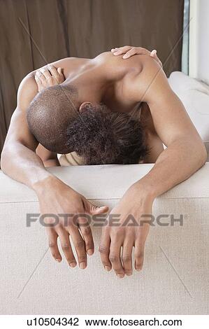 Stock Image - Intimate African American couple on sofa. Fotosearch