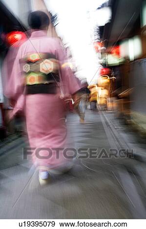 Stock Photo - Japan Kyoto Pontocho-dori Woman wearing kimono walking on narrow street motion blur. Fotosearch