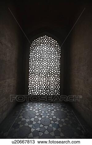 Stock Image - Light coming through stone lattice at Humayun's Tomb, New Delhi, India. Fotosearch