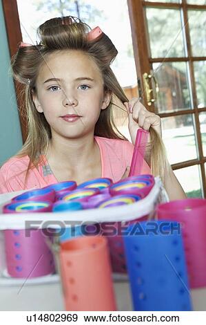 Little girl putting rollers in hair View Large Photo Image Stock Photo - Little girl putting rollers in hair. Fotosearch