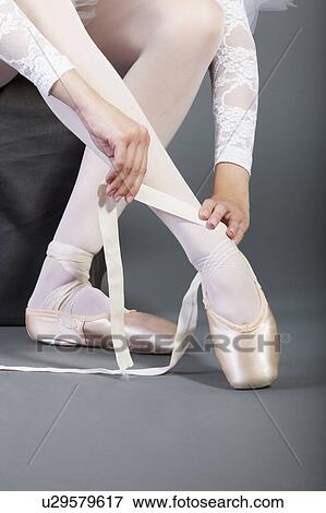 Low section of female ballet dancer tying pointe shoes View Large Photo Image Stock Photo - Low section of female ballet dancer tying pointe shoes. Fotosearch