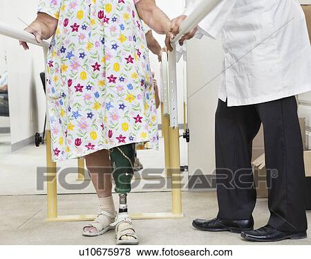 Stock Photo - Low section of female patient being assisted by a technician. Fotosearch