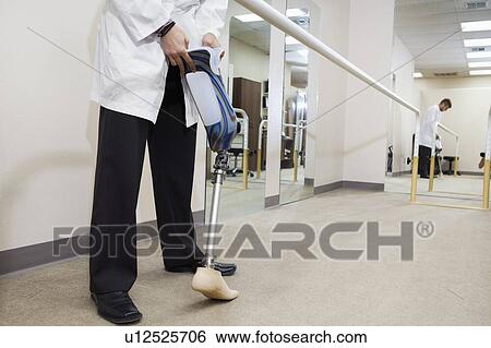 Stock Photograph - Low section of technician with advanced prosthetic foot. Fotosearch