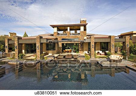 Stock Image - Luxury manor house with swimming pool in foreground. Fotosearch