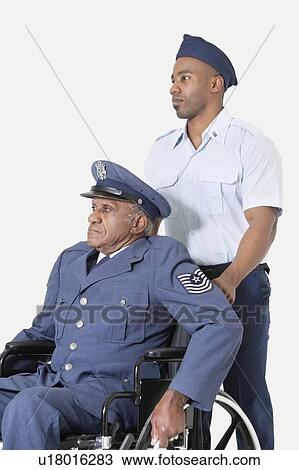 Male cadet assisting senior air force officer in wheelchair over light gray background View Large Photo Image Stock Image - Male cadet assisting senior air force officer in wheelchair over light gray background. Fotosearch