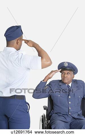 Male cadet saluting senior air force office in wheelchair over light gray background View Large Photo Image Picture - Male cadet saluting senior air force office in wheelchair over light gray background. Fotosearch