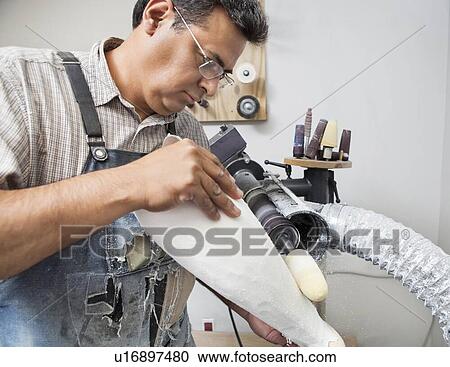Stock Image - Male worker buffing prosthetic limb. Fotosearch