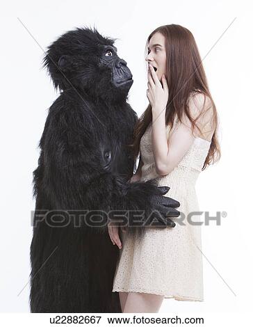 Man in gorilla costume hugging frightened young woman against white background View Large Photo Image Stock Photo - Man in gorilla costume hugging frightened young woman against white background. Fotosearch