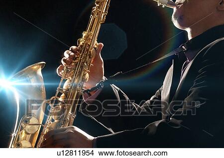 Picture - Man Playing Saxophone against black background. Fotosearch
