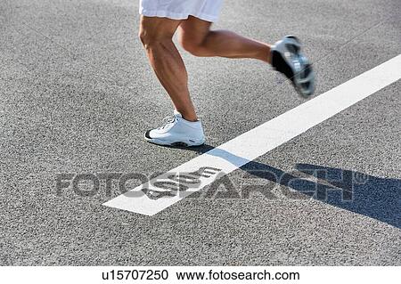 Stock Image - Man running on 400 meter dash. Fotosearch